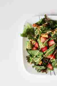 Dinner parties at home - image of a side alad with lettuce, strawberry and dressing on top